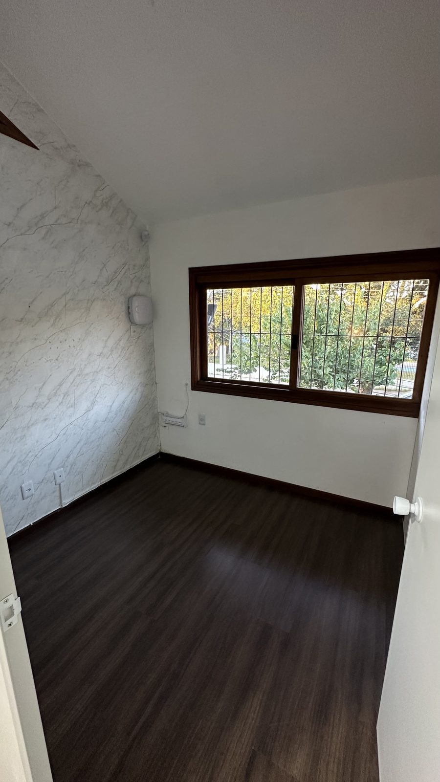 Pavimento superior — sala com parede em mármore